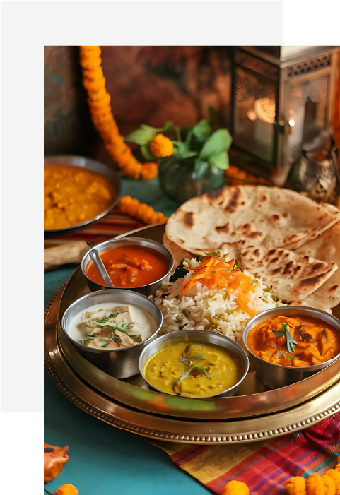 Traditional Indian thali with rice, naan, and various colorful curry and yogurt dishes on a decorative brass plate.